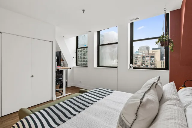 a bedroom with a bed and a painting on the wall