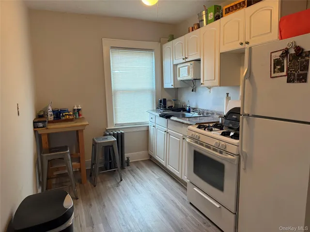 a kitchen with cabinets stainless steel appliances and wooden floor