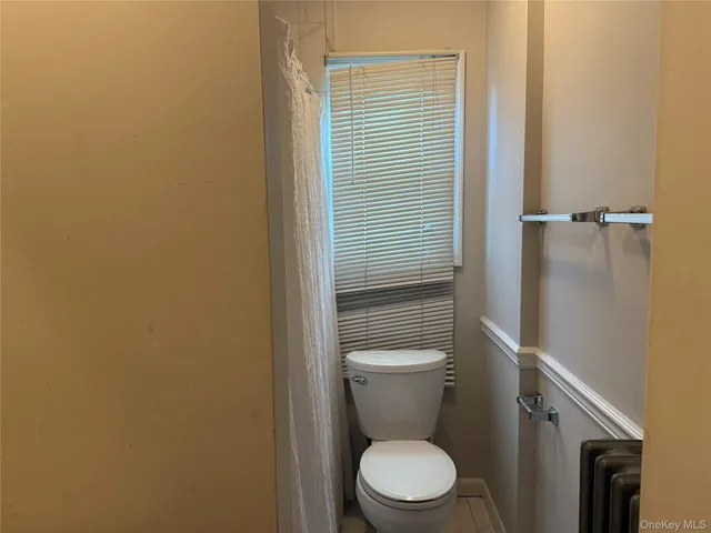 a white toilet sitting next to a shower