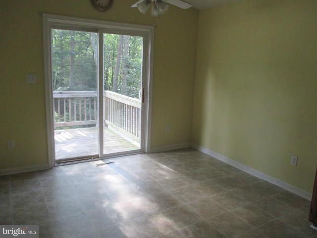 743 Lazy River Road Lusby, MD 20657 - Photo 12 of 16 an empty room with wooden floor and windows