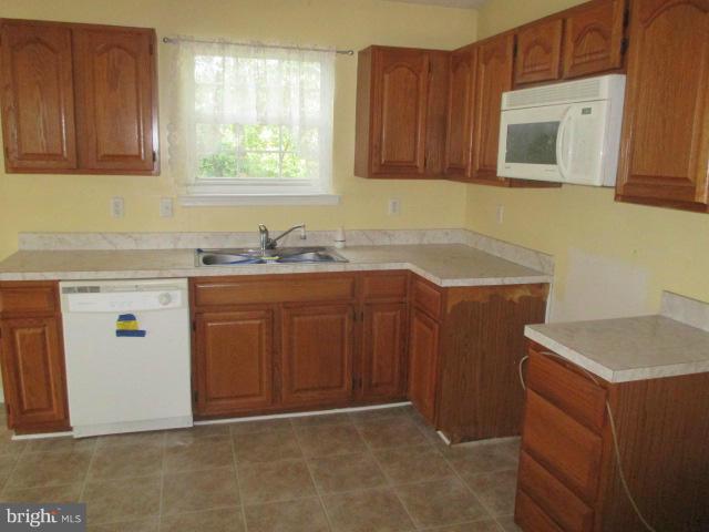 743 Lazy River Road Lusby, MD 20657 - Photo 13 of 16 a kitchen with stainless steel appliances granite countertop a sink stove and cabinets
