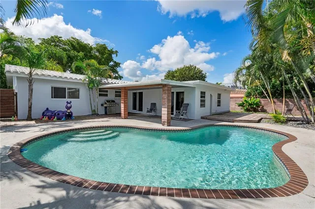 a view of a house with swimming pool and sitting area