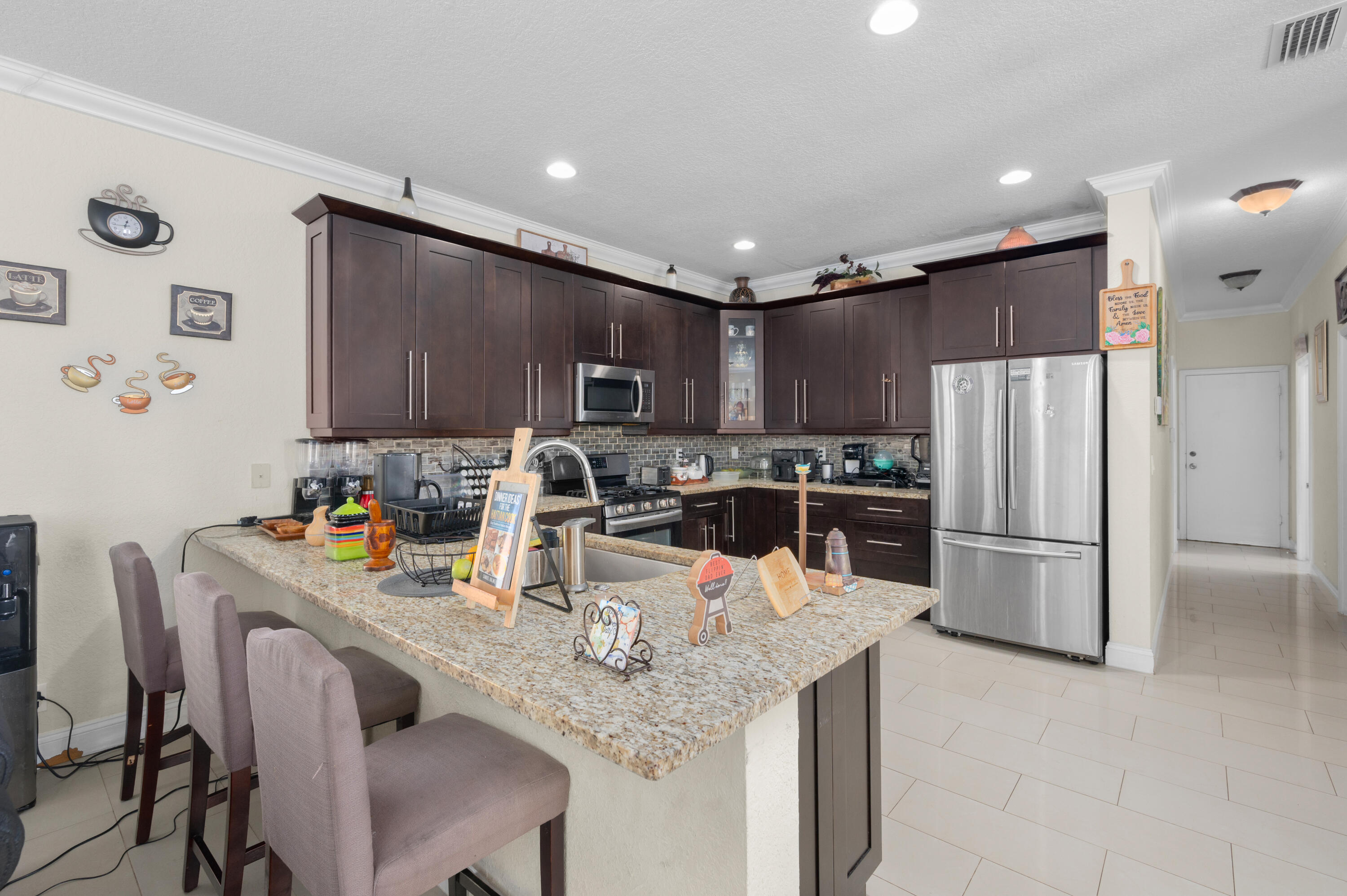 311 Berenger Walk Royal Palm Beach, FL 33414 - Photo 11 of 34 a kitchen with granite countertop a refrigerator and a stove top oven