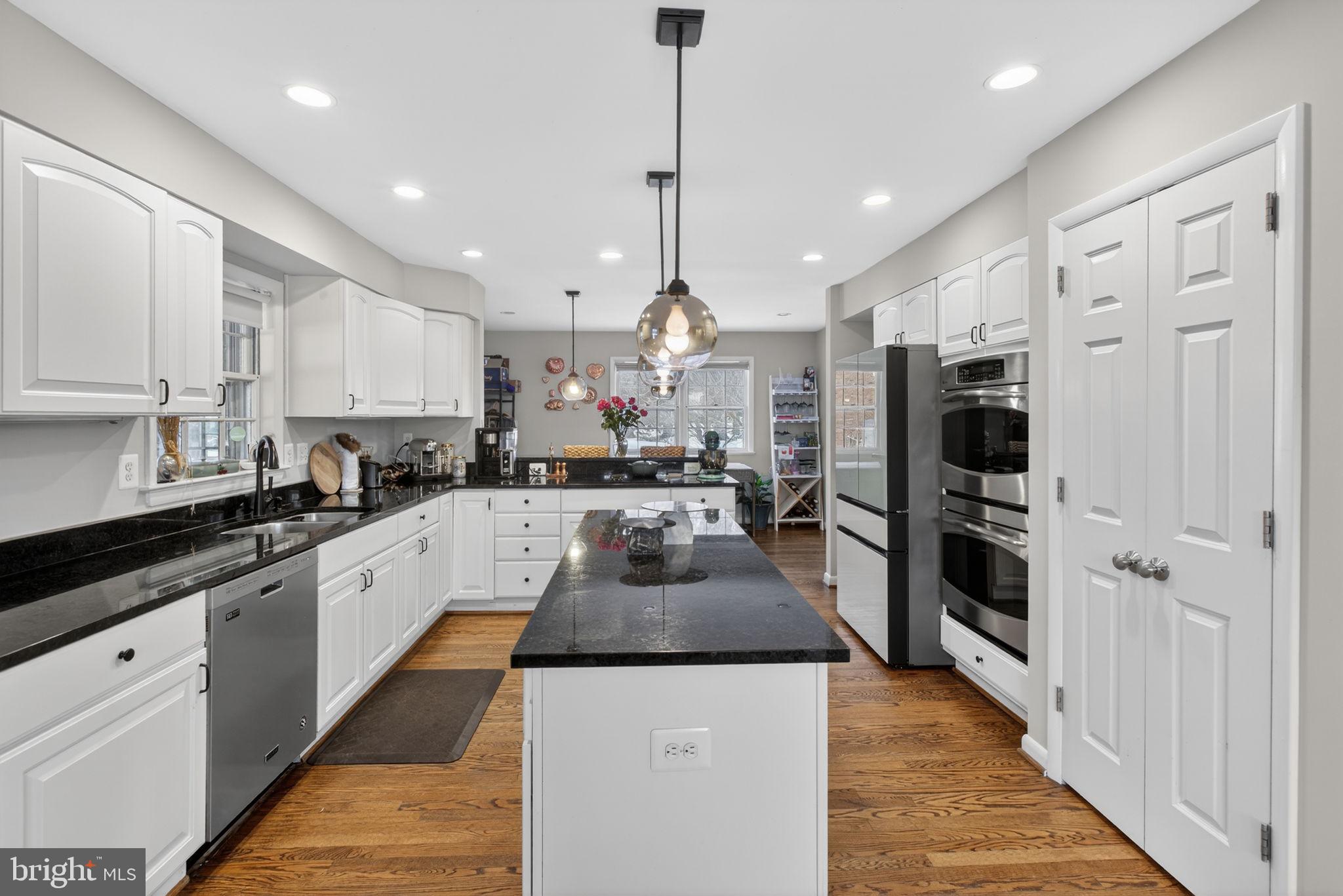 2849 Hideaway Road Fairfax, VA 22031 - Photo 5 of 45 a kitchen with granite countertop a refrigerator a sink dishwasher a stove and white cabinets with wooden floor