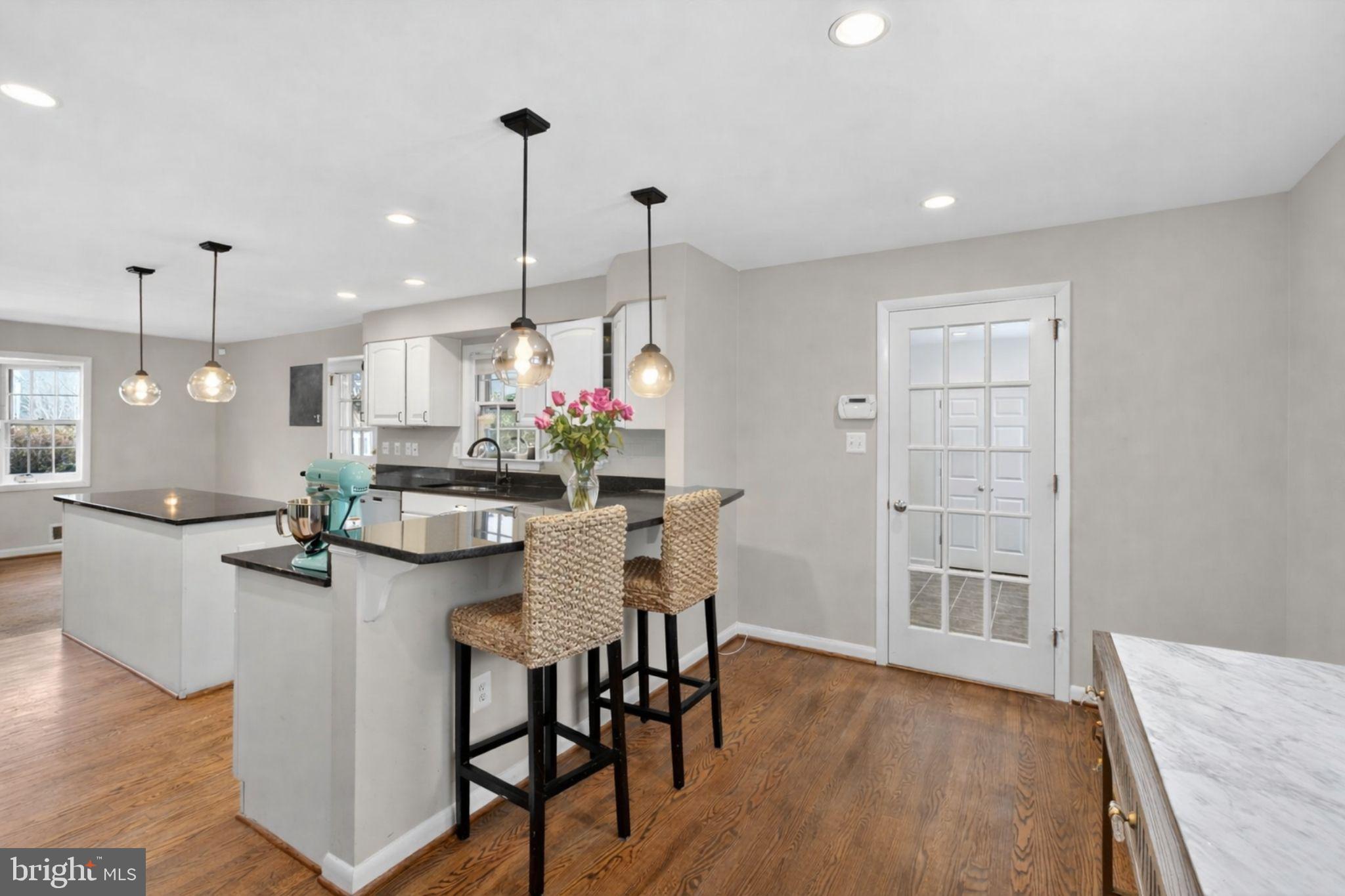 2849 Hideaway Road Fairfax, VA 22031 - Photo 7 of 45 a kitchen with kitchen island a dining table chairs and wooden floor