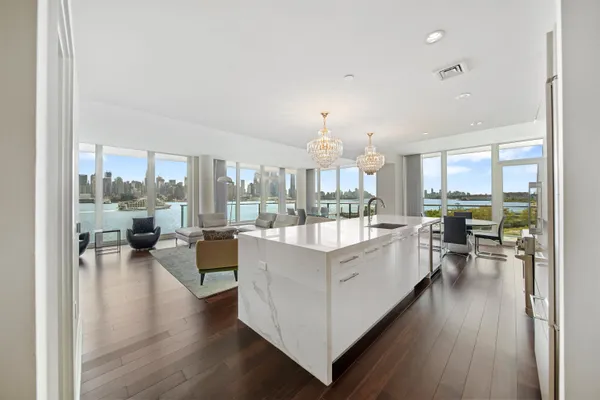 a large white kitchen with a large window and stainless steel appliances