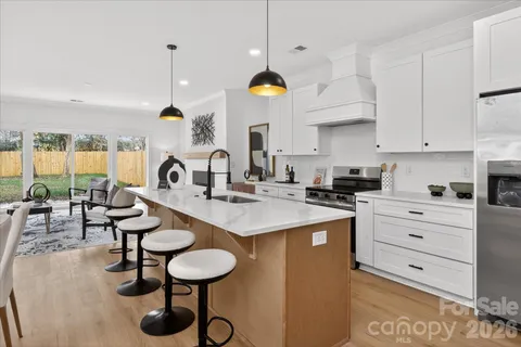 a kitchen with a sink a stove and chairs
