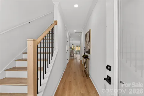 a view of a hallway with wooden floor and staircase