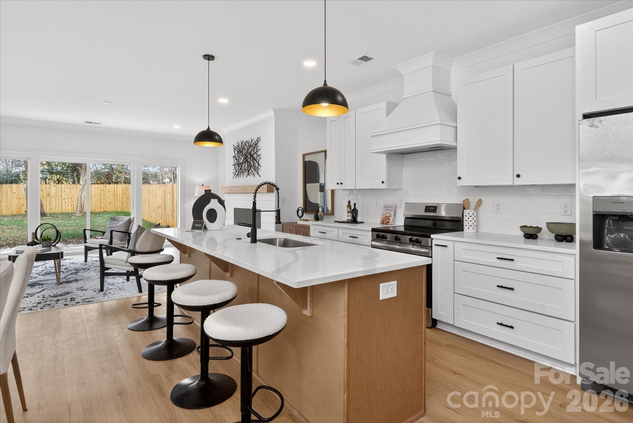 216 Lander Street Charlotte, NC 28208 - Photo 2 of 33 a kitchen with a sink a stove and chairs