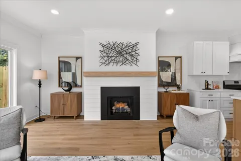 a living room with furniture a fireplace and kitchen view