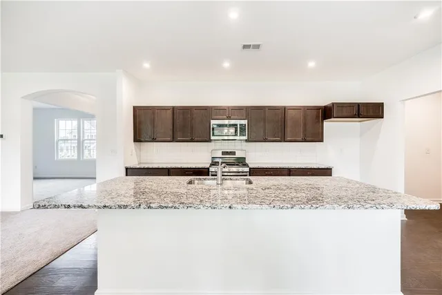 a kitchen with stainless steel appliances granite countertop a sink and a granite counter tops