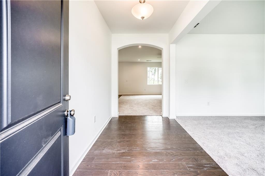 1377 R Liberty Park Drive Braselton, GA 30517 - Photo 37 of 38 a view of a hallway with wooden floor and a living room