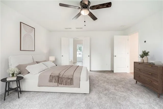 a spacious bedroom with a bed and ceiling fan