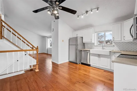 a kitchen with stainless steel appliances a stove a refrigerator cabinets and wooden floor