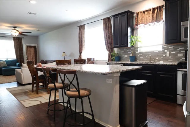 a kitchen with a table chairs sink and cabinets