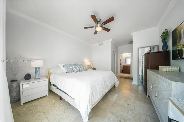 a spacious bedroom with a bed and a flat screen tv