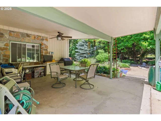 a view of a patio with table and chairs potted plants with floor to ceiling window