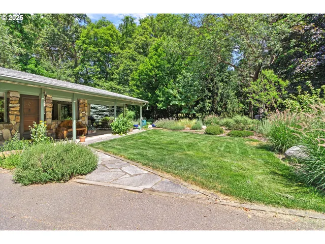 a view of house in front of a yard with potted plants
