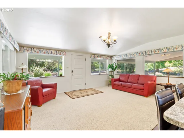 a living room with furniture a large window and a chandelier