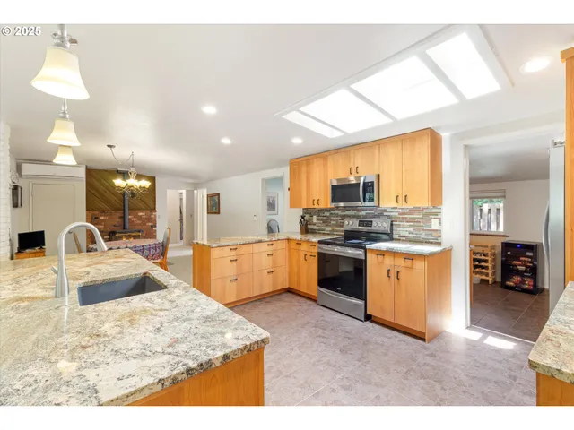 a large kitchen with granite countertop a large counter top stainless steel appliances and cabinets