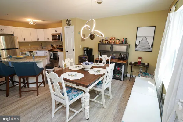 a dining room with stainless steel appliances kitchen island a table and chairs