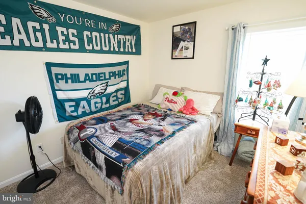 a bedroom with a bed a dresser and book shelf