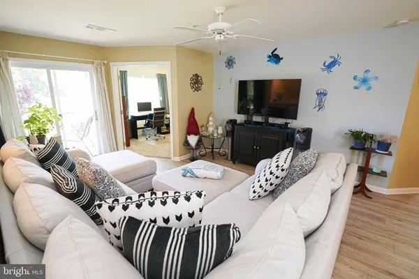 a living room with furniture a flat screen tv and a large window