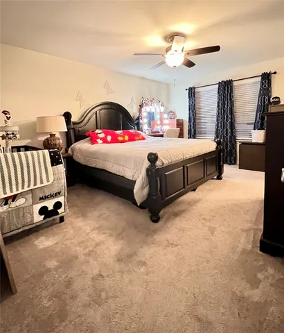 a bedroom with a bed a couch and a chandelier