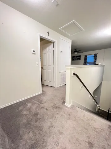 a view of a kitchen with refrigerator and white cabinets