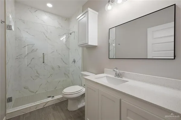 a bathroom with a sink a toilet and shower