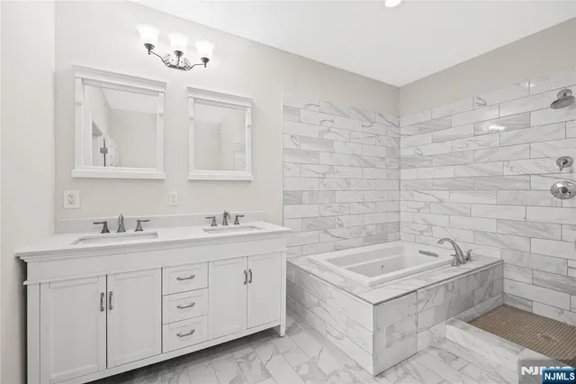 a spacious bathroom with a double vanity sink a mirror and a bathtub