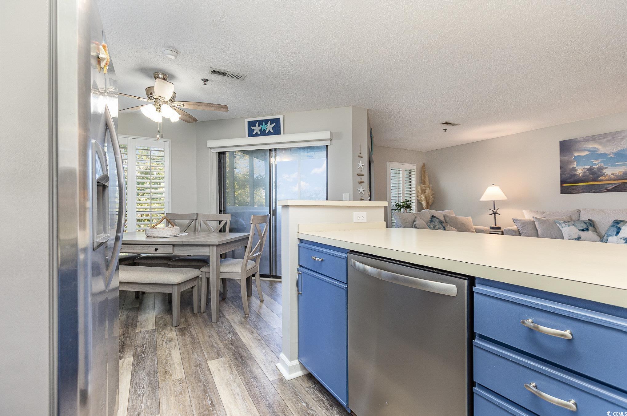 1101 Possum Trot Road, Unit B203 North Myrtle Beach, SC 29582 - Photo 11 of 37 Kitchen featuring ceiling fan, blue cabinetry, lig