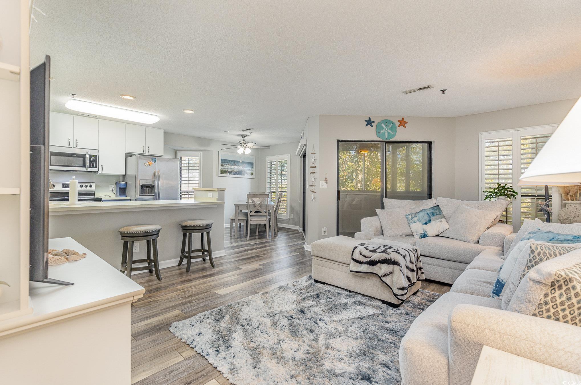 Living room with wood-type flooring and ceiling fa