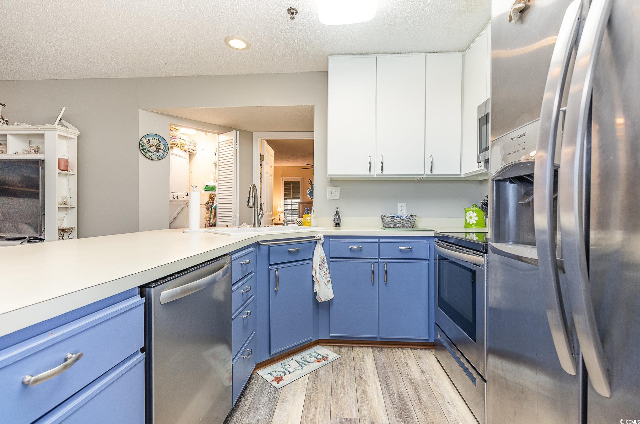 1101 Possum Trot Road, Unit B203 North Myrtle Beach, SC 29582 - Photo 10 of 37 Kitchen with blue cabinets, light wood-type floori