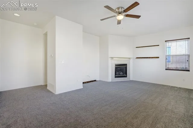 a view of a livingroom with a ceiling fan and window