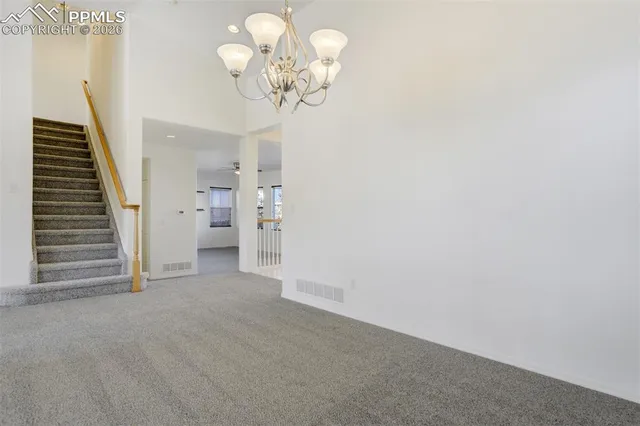 wooden floor in an empty room with a chandelier