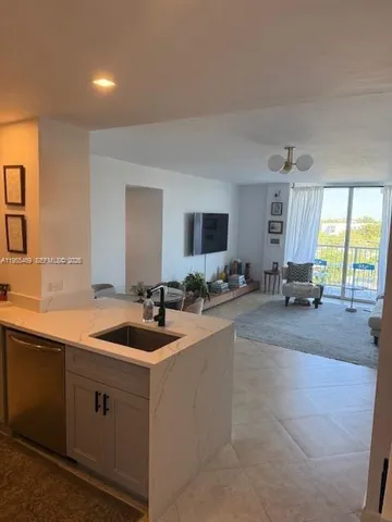 a kitchen with sink and mirror