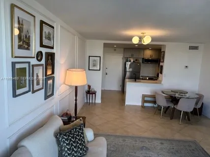 a living room with furniture a flat screen tv and a lamp