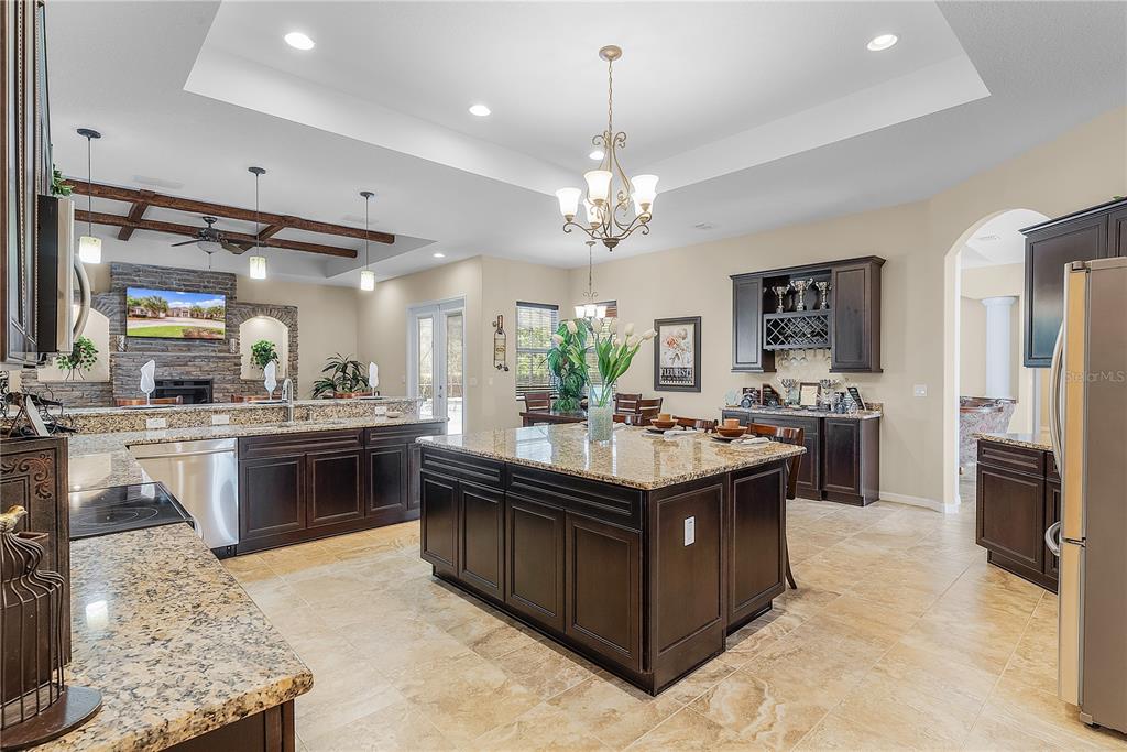 10710 Southwest 49th Avenue Ocala, FL 34476 - Photo 12 of 48 a large kitchen with kitchen island a sink stainless steel appliances and chandelier