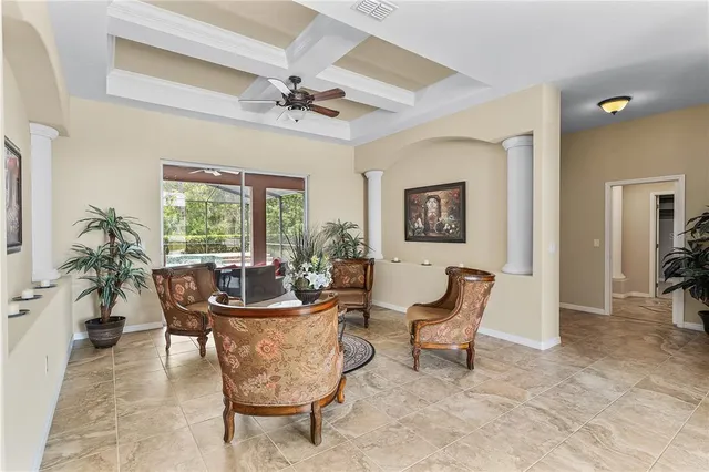a living room with furniture a window and a potted plant