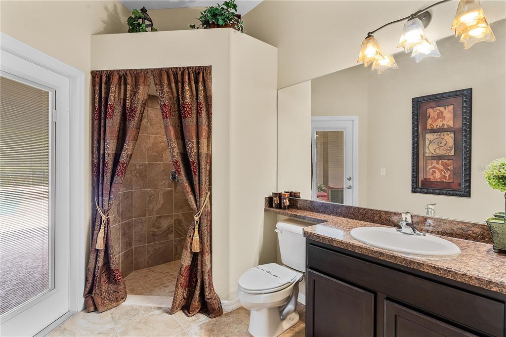 10710 Southwest 49th Avenue Ocala, FL 34476 - Photo 41 of 48 a bathroom with a granite countertop sink toilet and shower