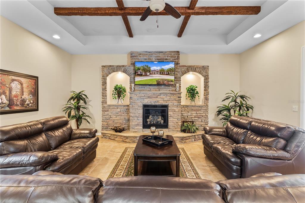 10710 Southwest 49th Avenue Ocala, FL 34476 - Photo 9 of 48 a living room with furniture a fireplace and a chandelier