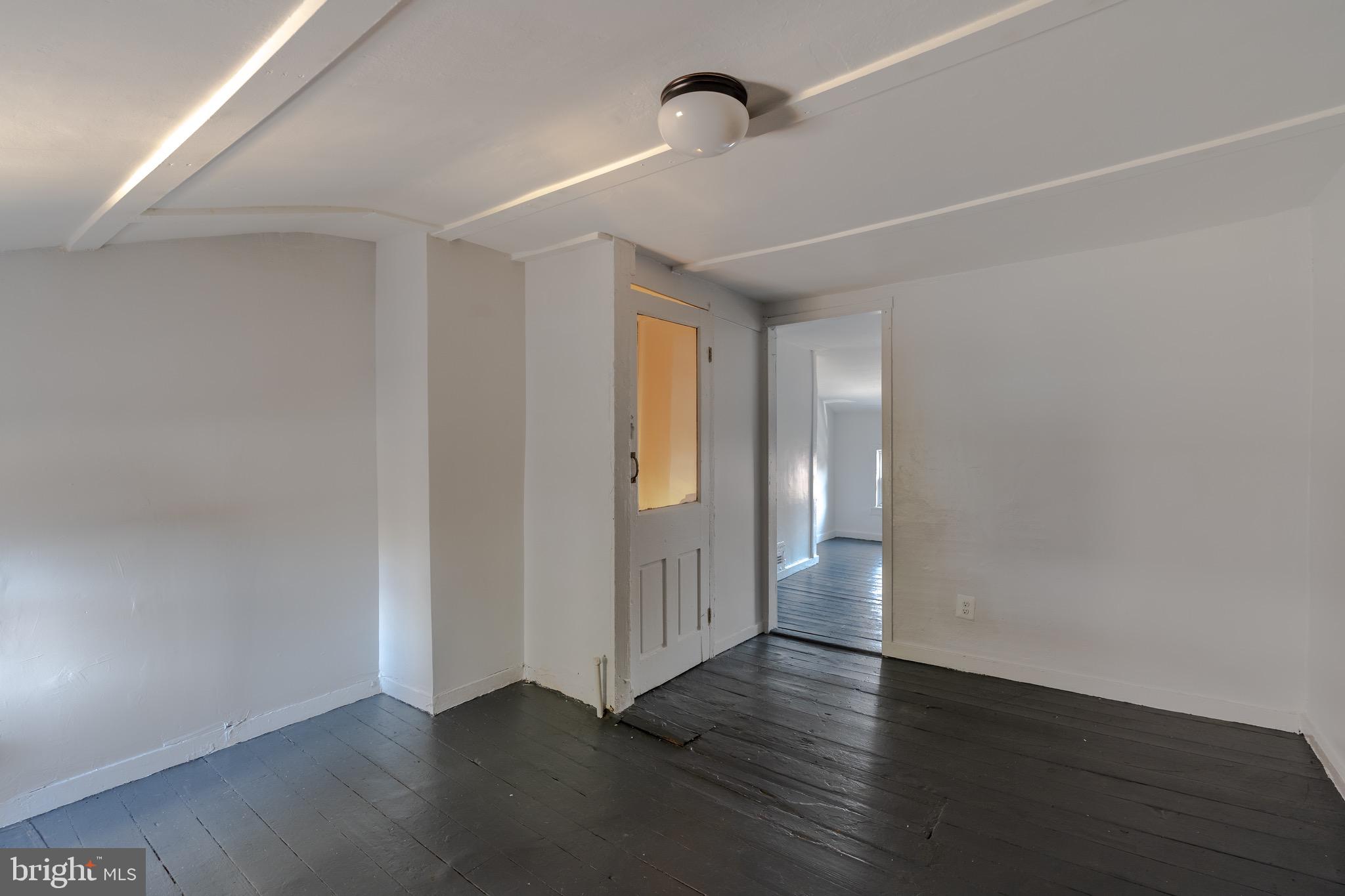 202 South Regester Street Baltimore, MD 21231 - Photo 11 of 15 a view of an empty room with wooden floor and a window