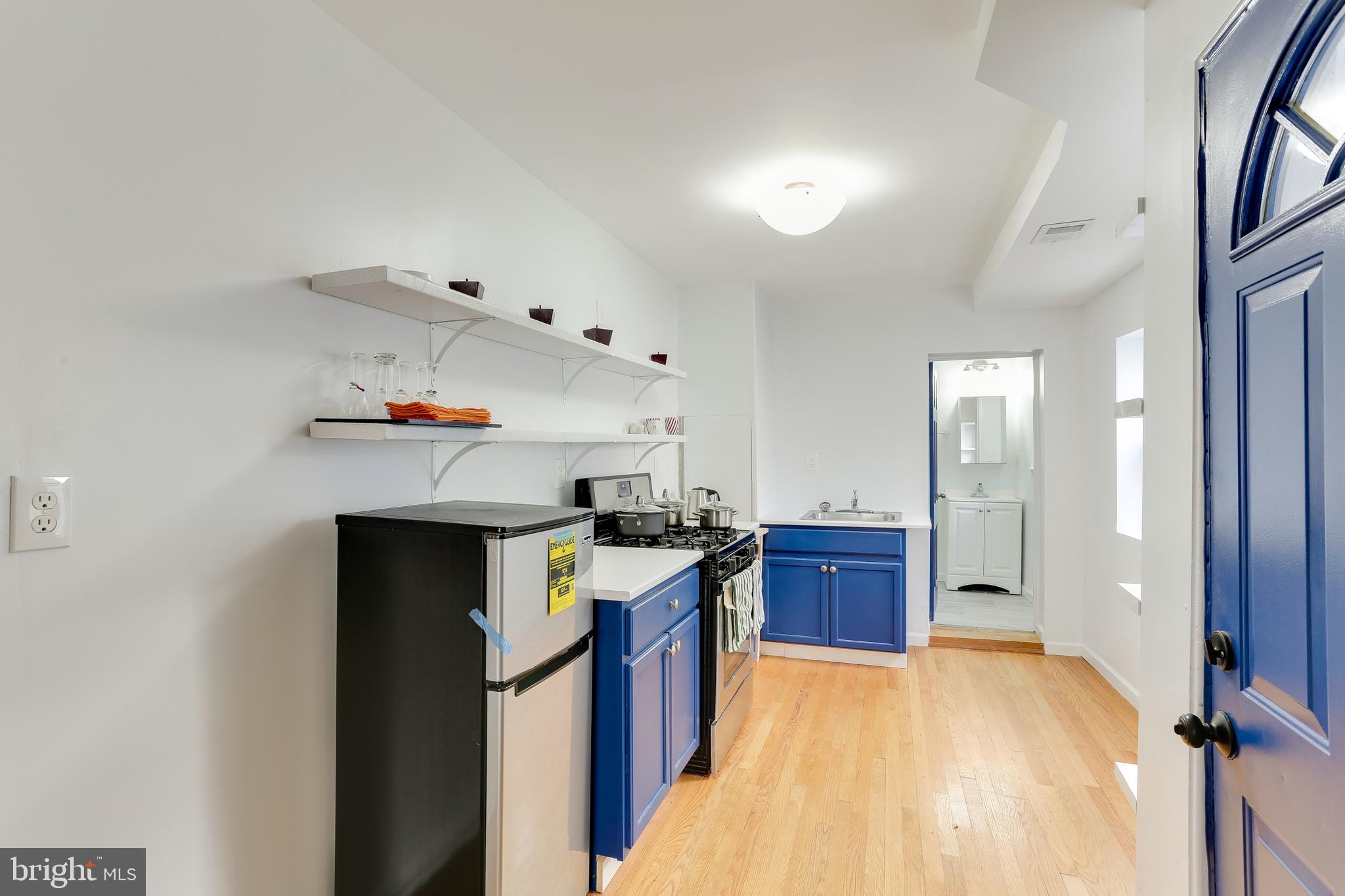 202 South Regester Street Baltimore, MD 21231 - Photo 2 of 15 a kitchen with cabinets and wooden floor