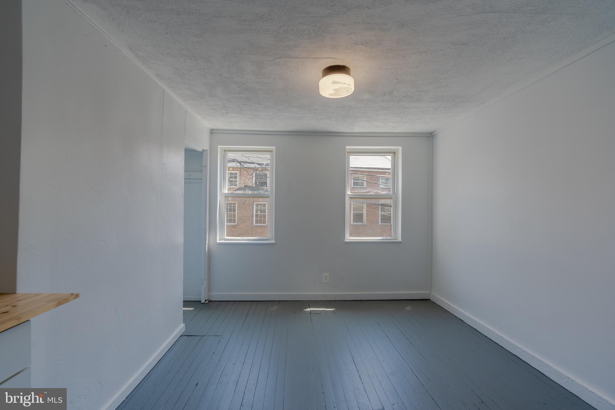 202 South Regester Street Baltimore, MD 21231 - Photo 7 of 15 an empty room with wooden floor and windows