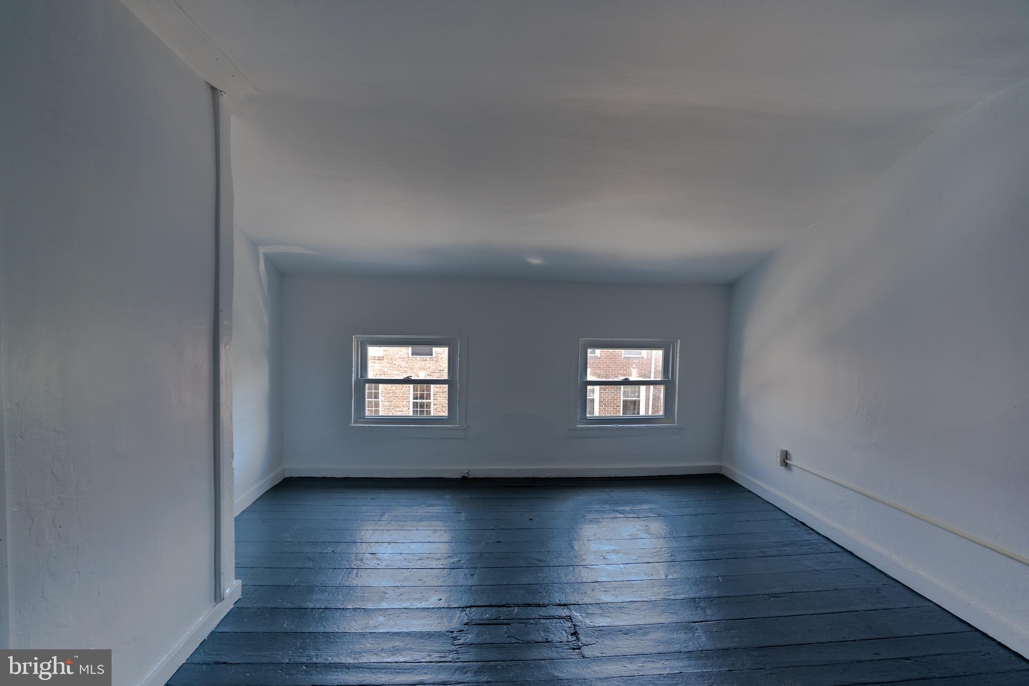 202 South Regester Street Baltimore, MD 21231 - Photo 9 of 15 a view of an empty room with wooden floor and a window