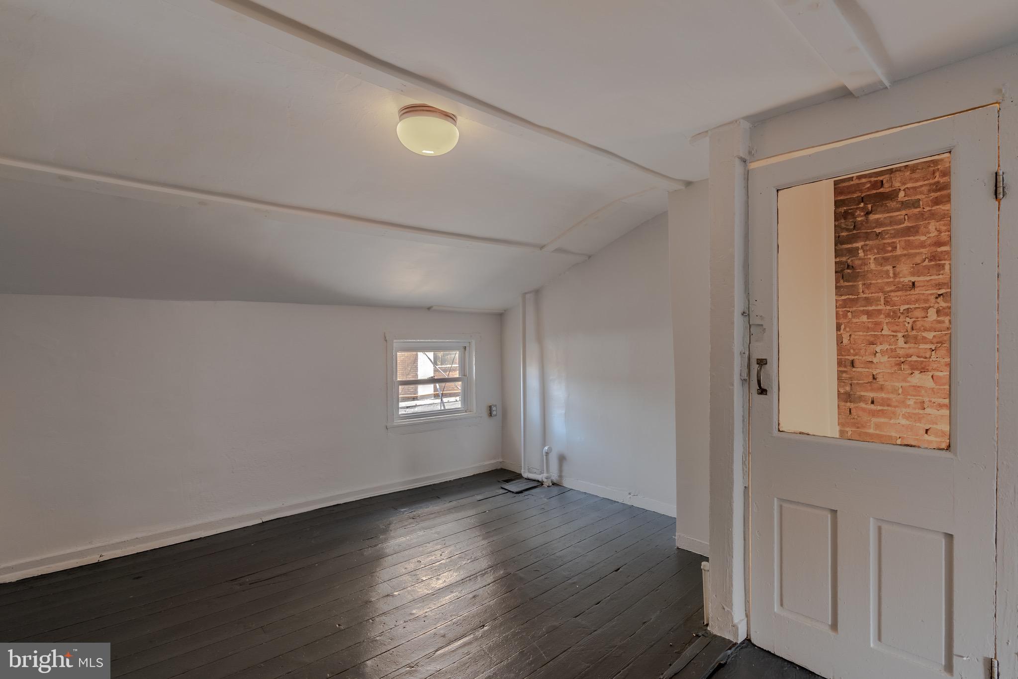202 South Regester Street Baltimore, MD 21231 - Photo 10 of 15 a view of an empty room with wooden floor and a window