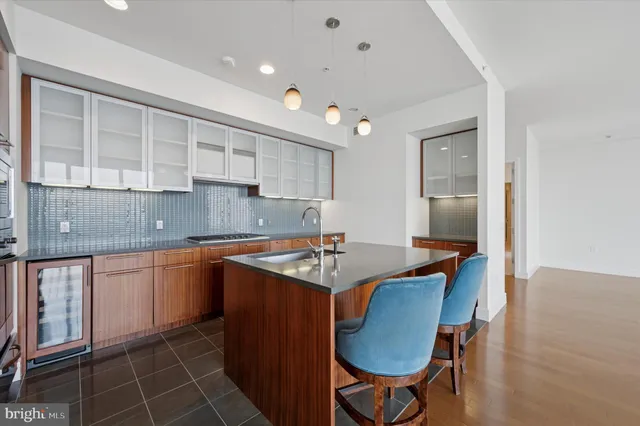 a kitchen with stainless steel appliances granite countertop a table chairs sink and cabinets