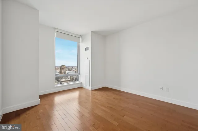 an empty room with wooden floor and a window