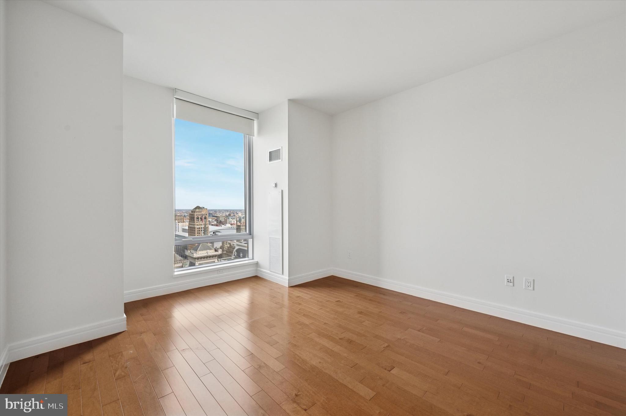 1414 South Penn Square, Unit 26CDE Philadelphia, PA 19102 - Photo 14 of 53 an empty room with wooden floor and a window